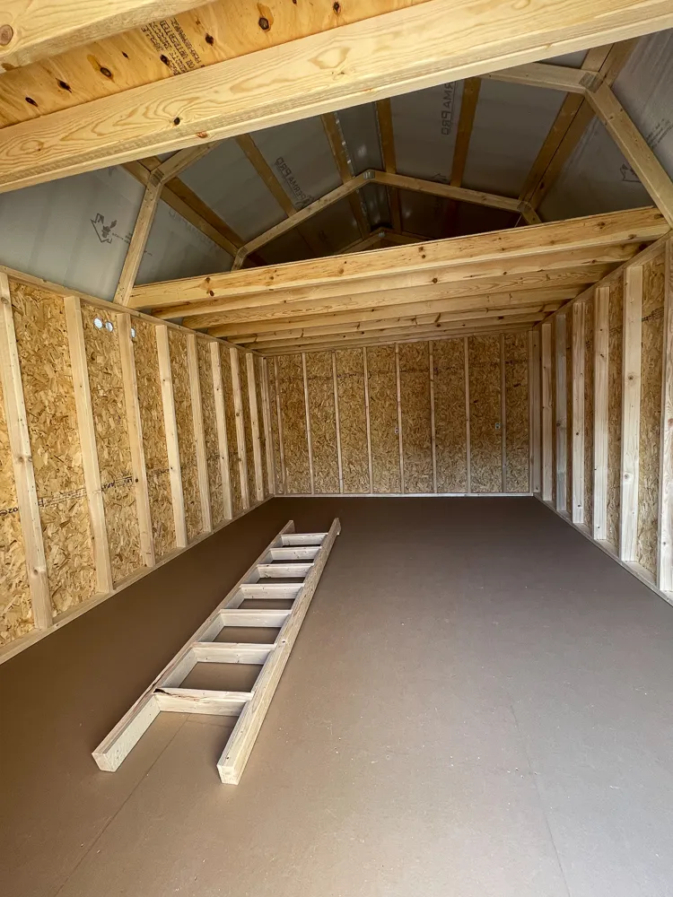 Inside a lofted barn shed, with a ladder leading up to the loft