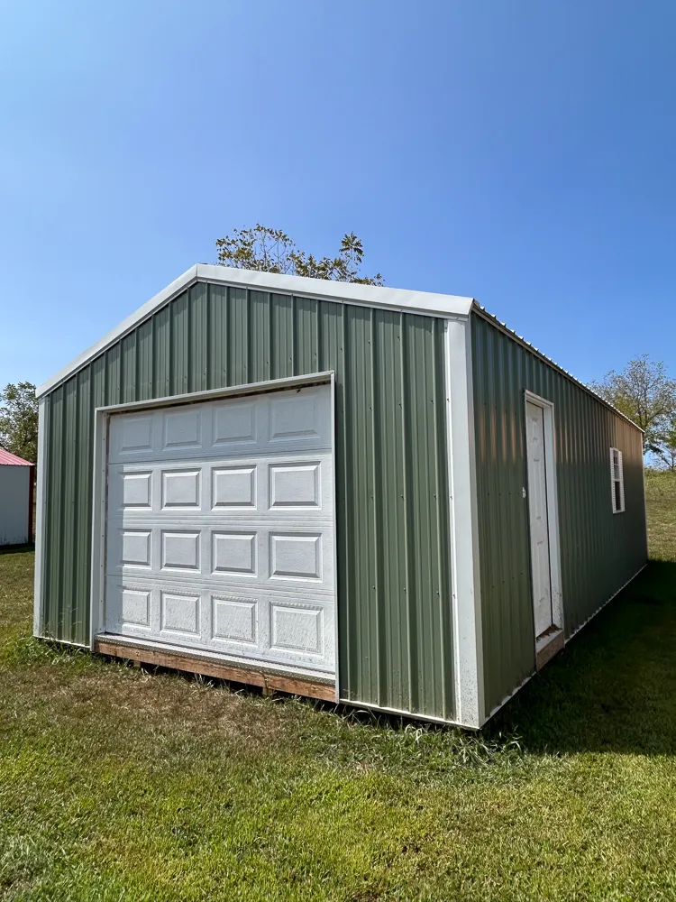 Green metal portable garage with a white roll-up door